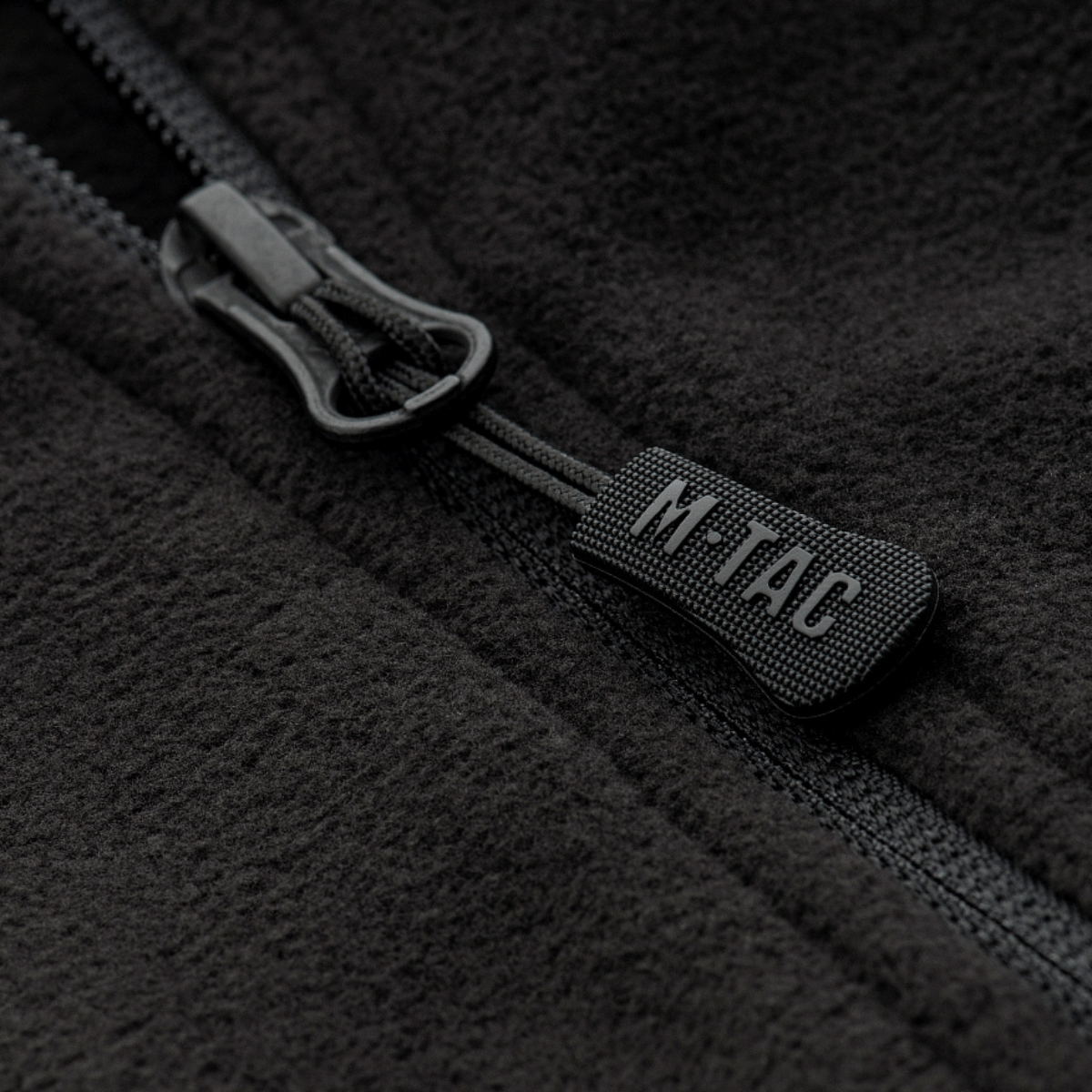 Nærbillede af M-Tac Delta Fleece Jakke lynlås, viser sort fleece stof og lynlåsdetaljer, ideel til udendørs brug i koldt vejr.
