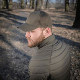 Mand iført M-Tac Mesh Flex Ripstop Baseball Cap i skov, viser holdbarhed og ventilation i udendørs omgivelser