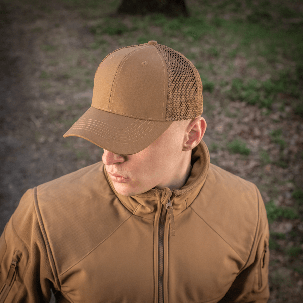 Mand iført M-Tac Mesh Flex Ripstop Baseball Cap i udendørs miljø, fremhæver kasketens holdbarhed og ventilation.