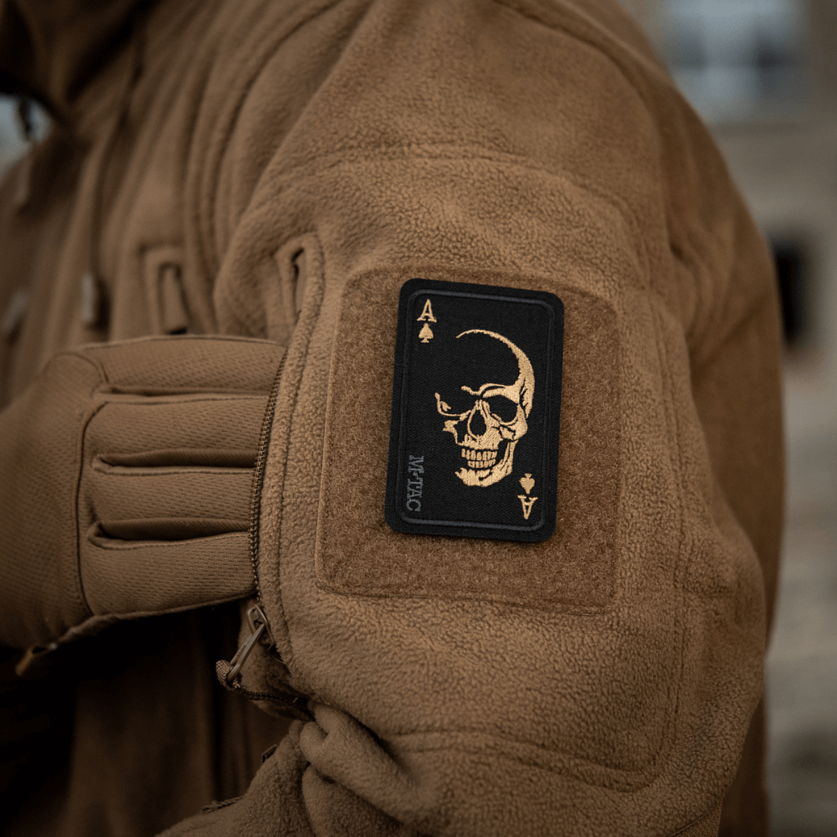 M-Tac Patch Face of War (Broderi) på en jakke med kraniesymbol på kort, inspireret af Vietnam "card of death", Cordura 500D, Velcro-monteret.