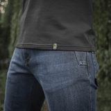 M-Tac Raglan T-Shirt 93/7 i tæt op med denim jeans, fremhæver åndbarhed og bevægelsesfrihed i naturen.