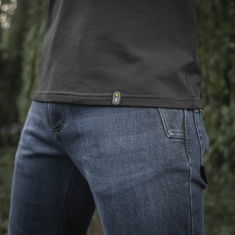 M-Tac Raglan T-Shirt 93/7 i tæt op med denim jeans, fremhæver åndbarhed og bevægelsesfrihed i naturen.