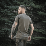 Mand iført M-Tac Sniper T-shirt i skovmiljø, bagfra, viser pasform og tætsiddende design