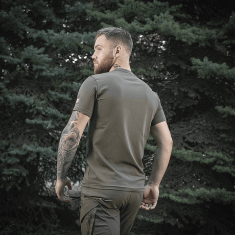 Mand iført M-Tac Sniper T-shirt i skovmiljø, bagfra, viser pasform og tætsiddende design
