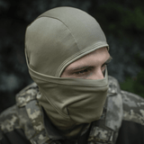 M-Tac Sweater-Ninja-Balaclava Premium til ansigtsbeskyttelse med Polartec® Power Dry-materiale i camouflage-miljø.