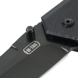 M-Tac Outdoor & Militær foldekniv - Type 5 med G10-komposit håndtag i nærbillede, viser rustfrit stål klinge og logo
