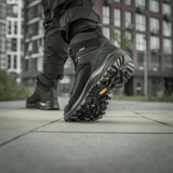 M-Tac Taktiske Demi-Season Støvler Pro Line med Vibram-sål til taktiske opgaver, visning af bund og greb i bymiljø.