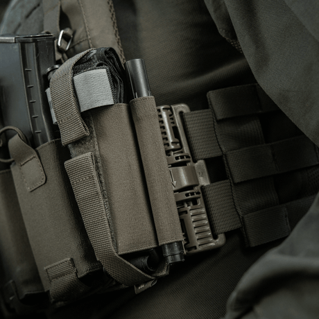 M‑Tac Tourniquet Pouch Elastic Gen.5 monteret på taktisk udstyr med elastisk velcro bånd, praktisk til CAT tourniquet.