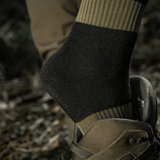 M-Tac Vinter Sokker med elastisk kant og anatomisk pasform for optimal komfort og varme under kolde forhold, set i en army-støvle.