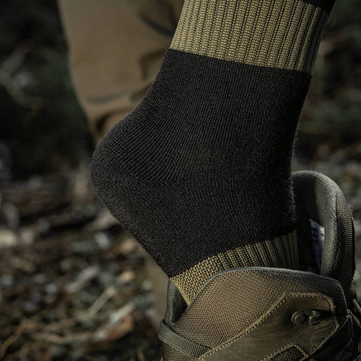 M-Tac Vinter Sokker med elastisk kant og anatomisk pasform for optimal komfort og varme under kolde forhold, set i en army-støvle.