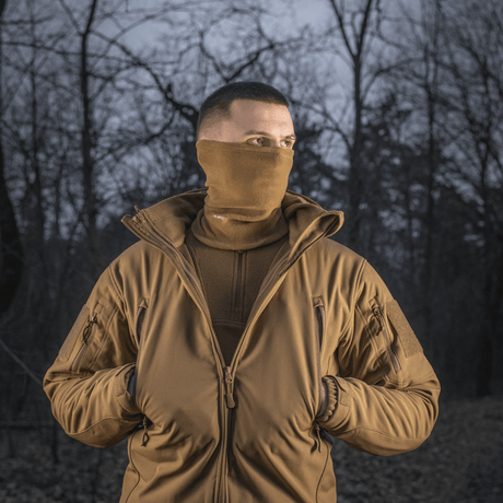 Mand iført M-Tac Tube Scarf Polartec i skov, perfekt til udendørs aktiviteter og koldt vejr.