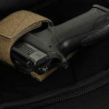 Nærbillede af en pistol i en M-Tac Sphaera Hardsling Bag Large Elite med Velcro, lavet af robust Cordura stof med velcro fastgørelse.