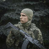 Soldat iført M-Tac Sweater-Ninja-Balaclava Premium i skovklædning, holder våben, optimal til fugthåndtering og komfort.