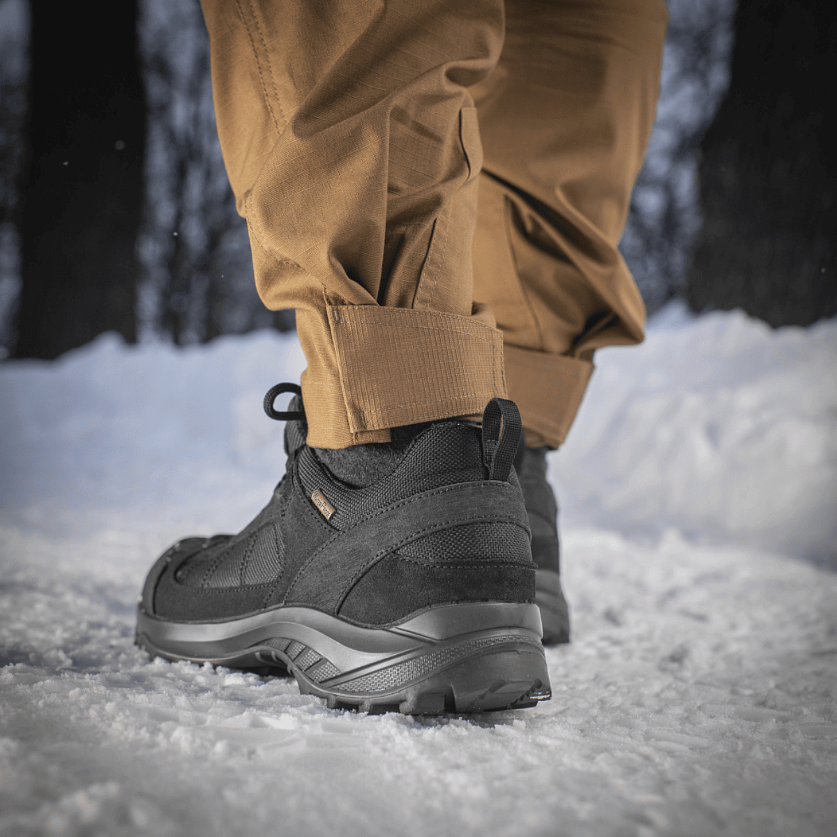 Person iført M-Tac Taktiske Bukser Patriot Gen. II Flex i sne, viser buksernes bevægelsesfrihed og praktiske design.