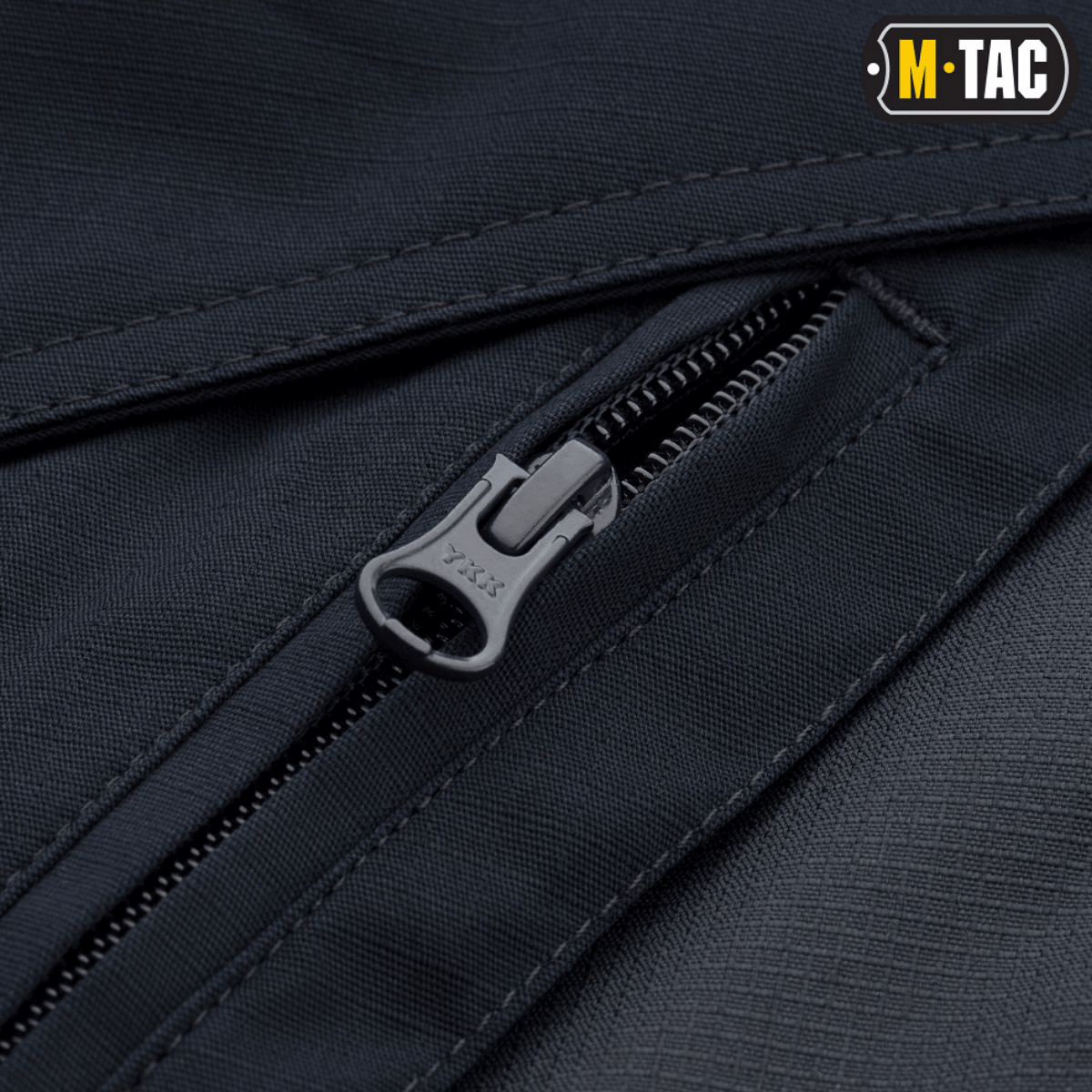 Nærbillede af lynlås på M-Tac Taktiske Bukser Aggressor Gen. II Flex med rip-stop stof og Teflon-belægning