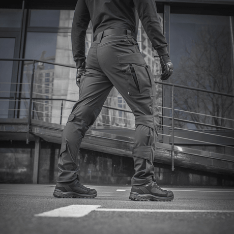 En person iført M-tac Taktiske Bukser Conquistador Gen. I Flex står udendørs, viser det slidstærke Rip-stop Flex stofdesign.