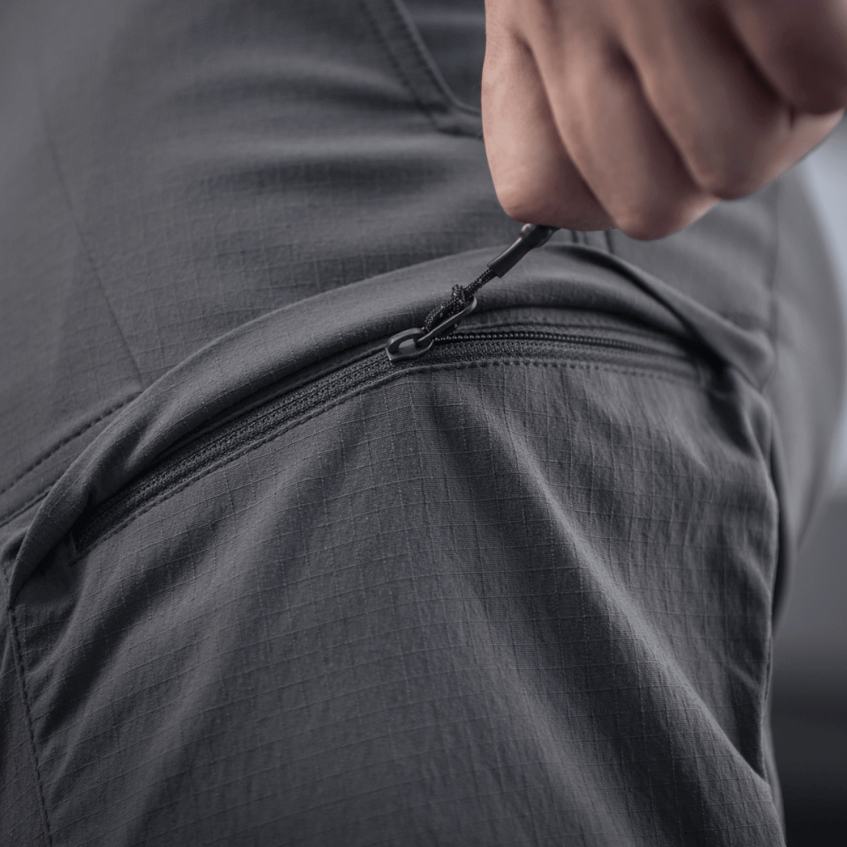 Nærbillede af lomme på M-Tac Bukser Sahara Flex Light, viser lynlåsdetaljer og fleksibelt materiale.