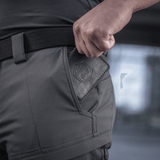 Mand iført M-Tac Bukser Sahara Flex Light med fokus på lomme detaljer, som viser slidstærkt og fleksibelt stof.