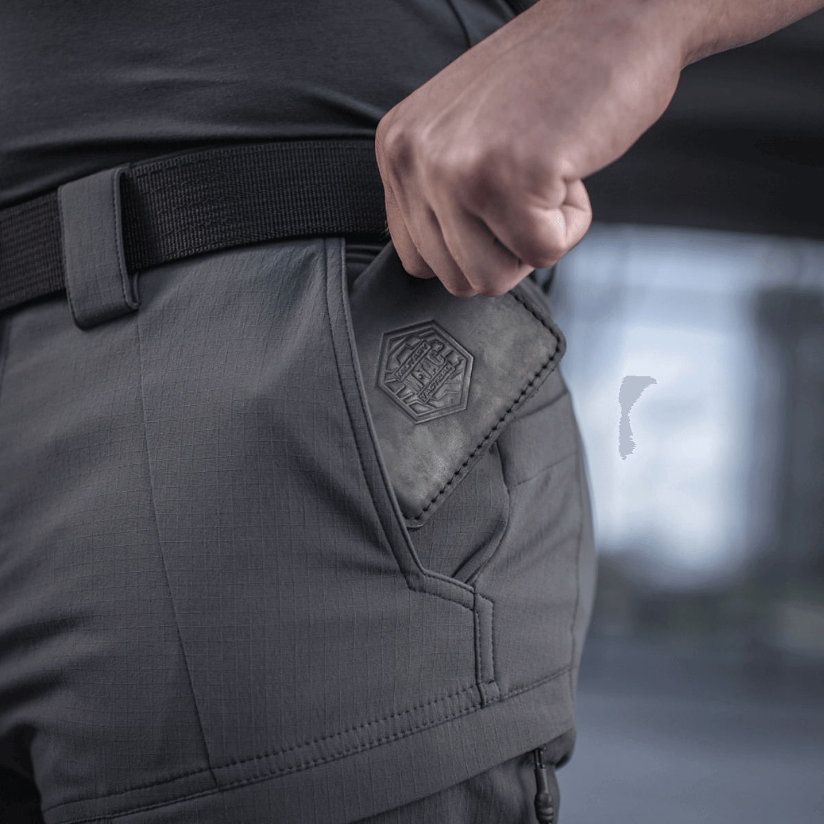 Mand iført M-Tac Bukser Sahara Flex Light med fokus på lomme detaljer, som viser slidstærkt og fleksibelt stof.