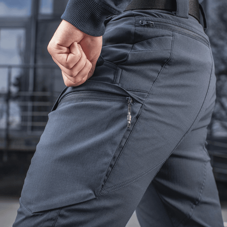 M-Tac Bukser Sahara Flex Light i grå med lynlåsdetaljer, fremhæver letvægtsdesign og fleksibilitet til sommerbrug.