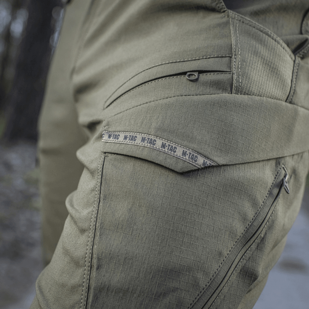Detaljer af M-Tac Bukser Aggressor Summer Flex i let Rip-Stop nylon, ideelle til taktisk brug og komfort i varmt vejr.