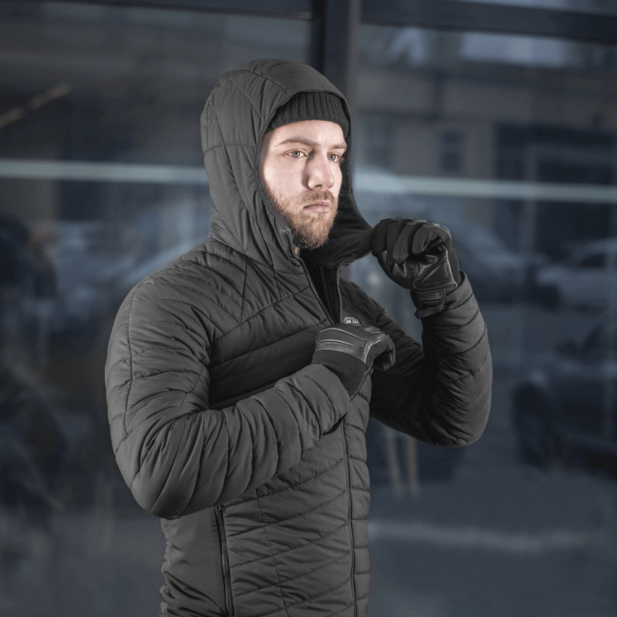 Mand iført M-Tac Jarl Jakke i sort, ideel til beskyttelse mod kulde og vind, lavet af Toray mechanical stretch nylon med G-Loft fyld.