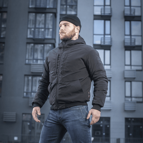 Mand iført M-Tac Rubicon Jakke Gen. II – Slidstærk og varm bomberjakke foran moderne bygning